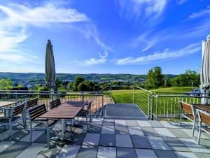 a patio with a table and chairs and a umbrella at Phönix Hotel in Bergneustadt
