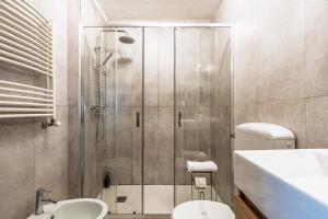 a bathroom with a shower and a toilet and a sink at ALPHIRA - Vista Montagne e Deposito per Sci e Bici in Pila +23 photos