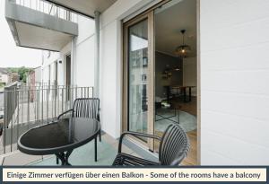 a balcony with a table and chairs and a window at LIVELY am Kaiserberg Duisburg in Duisburg +14 photos