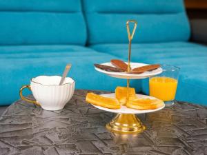 a table with two plates of bread and orange juice at Maison Maubert in Thiers