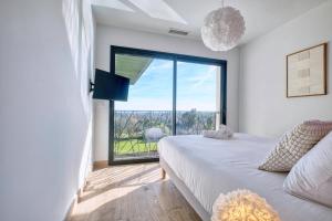 a bedroom with a bed and a large window at BELLEVUE 2, piscine, jacuzzi, sauna in Champcevinel