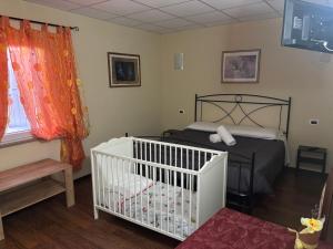 a bedroom with a crib in a room at Locanda del Principe in Soriano nel Cimino +39 photos