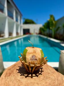 a coconut in a basket next to a swimming pool at Yahweh Hotel in São Miguel do Gostoso