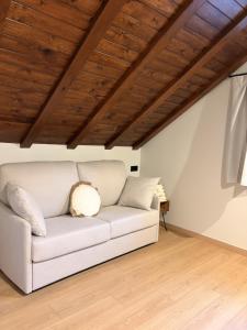 a white couch in a room with a wooden ceiling at Apartamentos St.Anton Suites Benasque in Benasque