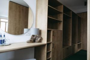 a dressing room with wooden cabinets and a mirror at Grünbauer - Der Landgasthof in Reuth bei Erbendorf