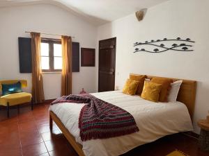 a bedroom with a large bed with yellow pillows at Quinta do Faisco in Évora +42 photos