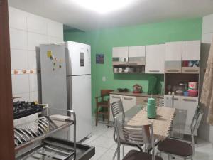 a kitchen with a table and a white refrigerator at Acomodações em Bananeiras, PB in Bananeiras