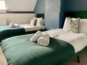 a room with a bed and a couch with two towels at Redesdale View, High Street with Private Garden in Moreton in Marsh