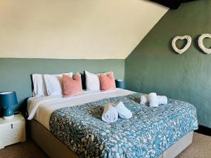 a bedroom with a large bed with towels on it at Redesdale View, High Street with Private Garden in Moreton in Marsh +22 photos