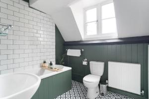 a bathroom with a toilet and a tub and a sink at Redesdale View, High Street with Private Garden in Moreton in Marsh