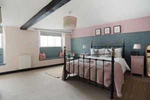 a bedroom with a bed and a blue and pink wall at Redesdale View, High Street with Private Garden in Moreton in Marsh