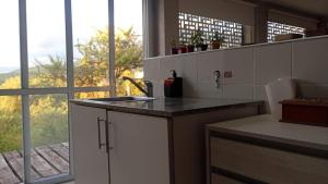 a kitchen with a counter with a sink and a window at Uritorco Flats in Capilla del Monte