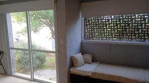 a room with a window with a bed and a window at Uritorco Flats in Capilla del Monte