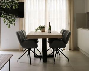 a table with a bottle of wine and four chairs at Casa la Pluma Torrevieja in Torrevieja