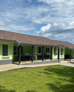a green building with a picnic table in it at Bungalovy CLASSIC & Wellness Podhájska - Adults Only in Podhájska