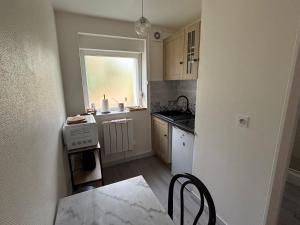 a small kitchen with a table and a window at Sur Egletons - Le Cocon Egletons in Égletons