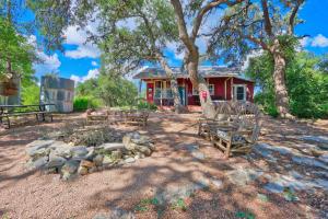a red house with a fire pit in front of it at Sunflower Ridge Cabin in San Marcos