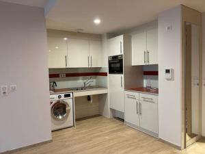 a kitchen with white cabinets and a washing machine at Appart One Aix-les-Bains in Aix-les-Bains