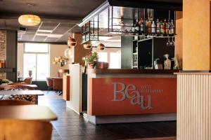 a restaurant with a bar in the middle of a room at Hotel BEAU in Bergeijk +17 photos