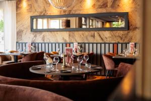 a restaurant with tables and chairs and a mirror at Hotel BEAU in Bergeijk