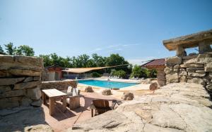 a resort with a pool and a stone wall at Lodge Holidays - Les 3 Cantons in Saint-Antonin