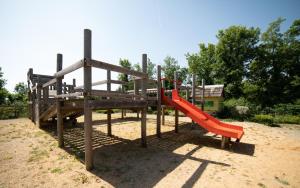 a playground with a red slide in the sand at Lodge Holidays - Les 3 Cantons in Saint-Antonin