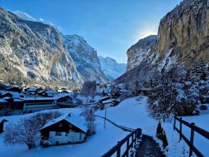 a village covered in snow with mountains in the background at Chalet Bellevue Beautiful Waterfall view private Garden & free parking in Lauterbrunnen