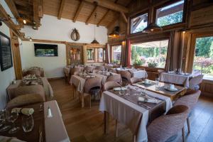 a dining room with tables and chairs and windows at La Ferme Du Lac in Thyez