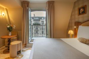 a hotel room with a bed and a large window at Hôtel La Bourdonnais by Inwood Hotels in Paris