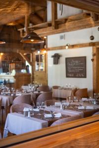 a restaurant with white tables and chairs and a chalkboard at La Ferme Du Lac in Thyez