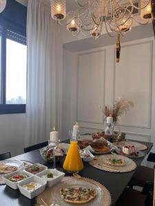 a table with many plates of food on it at Sunset Home - Netanya Roof & Sea View in Netanya +37 photos