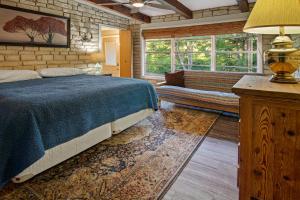 a bedroom with a bed and a couch and windows at Stone River Cabin in Canyon Lake