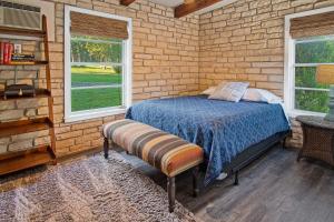 a bedroom with a bed and a brick wall at Stone River Cabin in Canyon Lake +13 photos