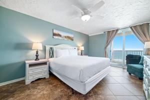 a bedroom with a bed and a blue wall at Romar Tower Unit 9D in Orange Beach