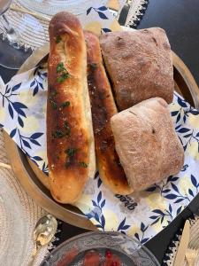 a plate of food with two hot dogs and bread at Sunset Home - Netanya Roof & Sea View in Netanya