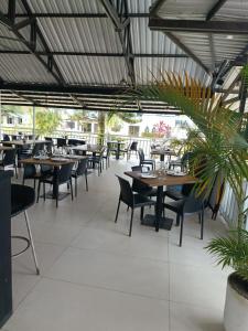 an empty restaurant with tables and chairs and plants at Hotel & Resort Villa del Sol in Tumaco