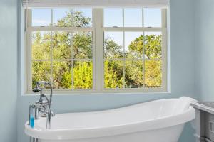a white bath tub in a bathroom with a window at Stone Ridge Retreat in Canyon Lake
