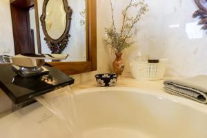 a bathroom with a white tub and a mirror at Guest H4U Villa Garden & Pool in Póvoa de Varzim