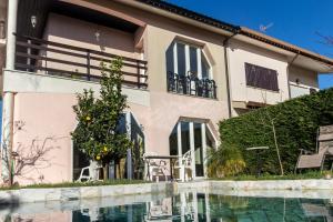 a house with a swimming pool in front of it at Guest H4U Villa Garden & Pool in Póvoa de Varzim