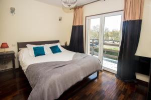 a bedroom with a bed with blue pillows and a window at Guest H4U Villa Garden & Pool in Póvoa de Varzim
