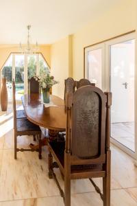 a dining room with a wooden table and chairs at Guest H4U Villa Garden & Pool in Póvoa de Varzim