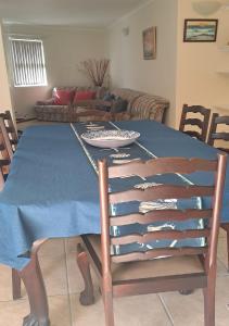 a dining room table with a blue table cloth on it at Outeniqua Strandwoonstel in Great Brak River