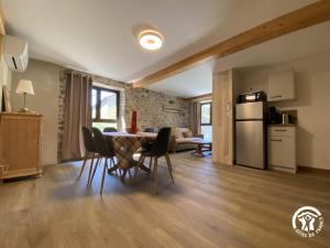 a kitchen and living room with a table and chairs at Petit péric in Puyvalador