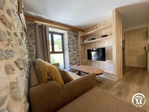 a living room with a couch and a table at Petit péric in Puyvalador