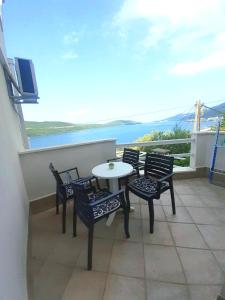 a table and chairs on a balcony with a view at Apartmani ROKO in Neum