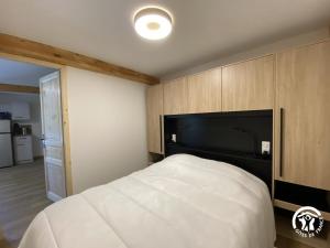 a bedroom with a large white bed with a black headboard at Petit péric in Puyvalador