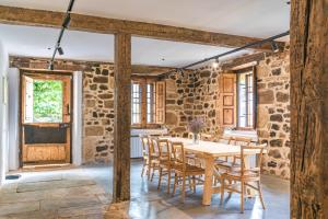 a dining room with stone walls and a table and chairs at La Villa de Carla in Borleña