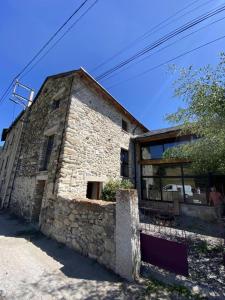 a stone building with a stone wall next to at Petit péric in Puyvalador