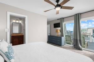 a bedroom with a bed and a tv and a window at Boardwalk Unit A18 in Pensacola Beach