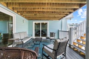 a patio with chairs and a couch on a porch at Boardwalk Unit A18 in Pensacola Beach